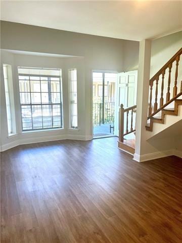 248 Cherokee St Unit 30, New Orleans, LA 70118 - unfurnished living room featuring baseboards, dark wood finished floors, and stairs