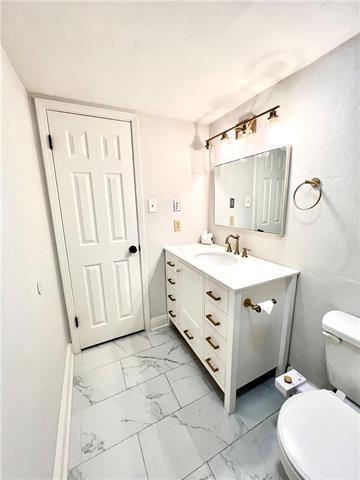 248 Cherokee St Unit 30, New Orleans, LA 70118 - half bath with marble look tile flooring, toilet, and vanity