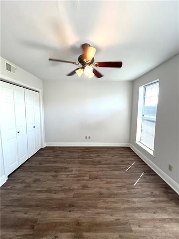 248 Cherokee St Unit 30, New Orleans, LA 70118 - unfurnished bedroom with baseboards, dark wood-style flooring, a closet, and ceiling fan