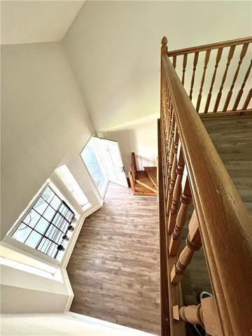 248 Cherokee St Unit 30, New Orleans, LA 70118 - staircase featuring high vaulted ceiling and wood finished floors