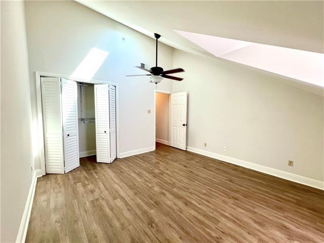 248 Cherokee St Unit 30, New Orleans, LA 70118 - unfurnished bedroom featuring wood finished floors, baseboards, high vaulted ceiling, a closet, and a ceiling fan