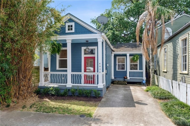shotgun-style home with a porch and driveway