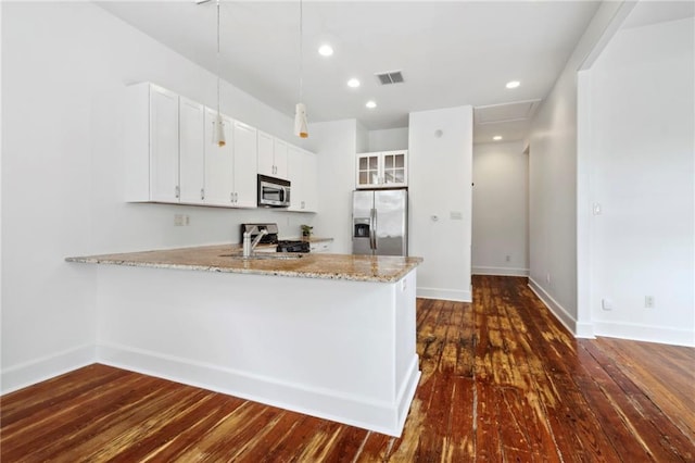 kitchen featuring baseboards, visible vents, stainless steel appliances, and a peninsula