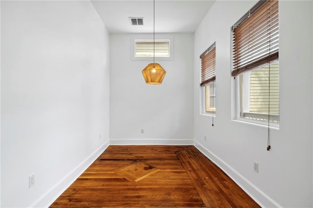 unfurnished dining area featuring visible vents, wood finished floors, and baseboards