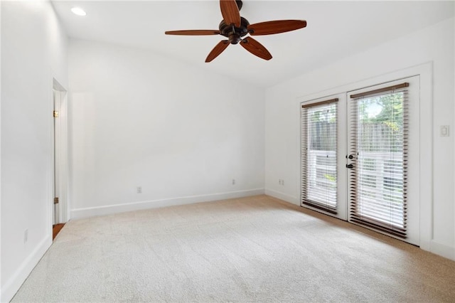 unfurnished room featuring ceiling fan, baseboards, light colored carpet, french doors, and lofted ceiling