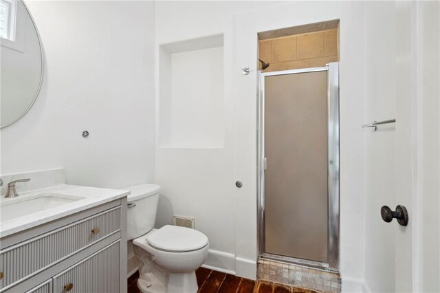 full bath featuring vanity, toilet, a stall shower, visible vents, and baseboards