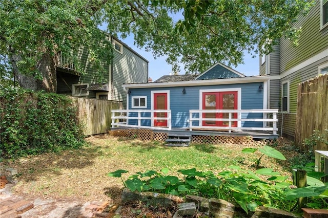 back of house with a chimney, fence, and a wooden deck