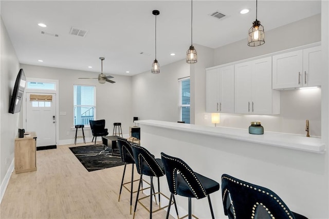 4228 Erato St, New Orleans, LA 70125 - kitchen featuring ceiling fan, visible vents, light wood-type flooring, and white cabinetry