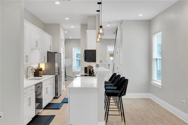 4228 Erato St, New Orleans, LA 70125 - kitchen featuring a center island, a sink, appliances with stainless steel finishes, and a healthy amount of sunlight