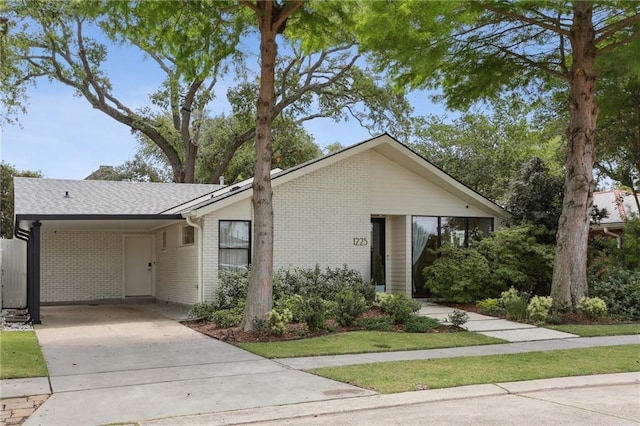 ranch-style house with brick siding, driveway, and an attached carport