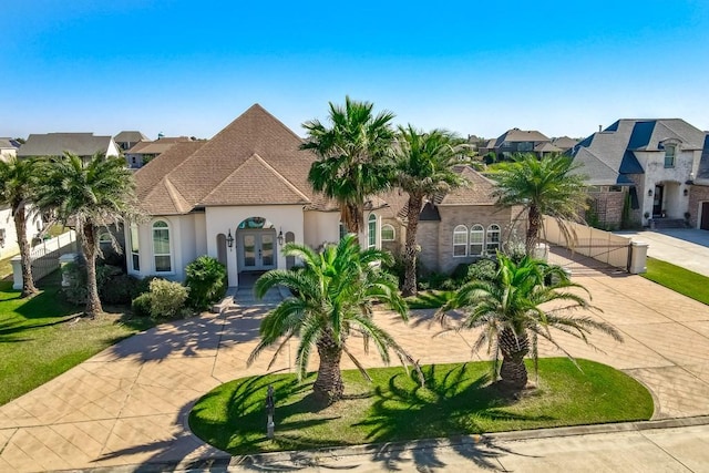 1270 Cutter Cv, Slidell, LA 70458 - french country inspired facade with french doors, curved driveway, stucco siding, and a residential view