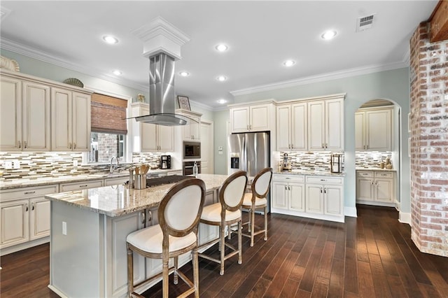 274 W Longview Ct, Madisonville, LA 70447 - kitchen with stainless steel appliances, decorative backsplash, cream cabinets, and a kitchen island