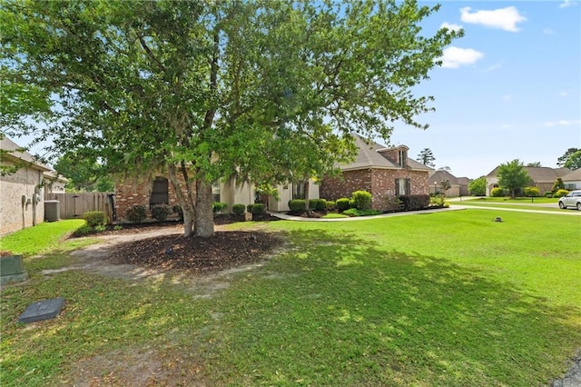 274 W Longview Ct, Madisonville, LA 70447 - obstructed view of property with brick siding, fence, a front yard, and a residential view