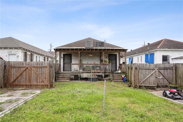 back of property with a gate, a yard, and a fenced backyard