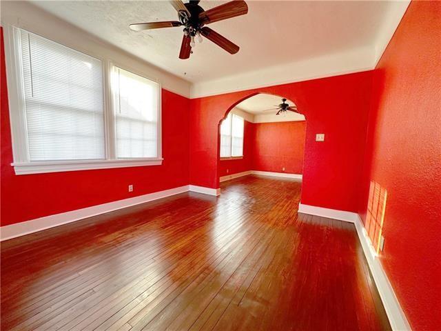 spare room featuring hardwood / wood-style flooring, a ceiling fan, baseboards, and arched walkways