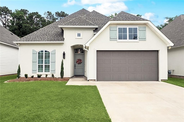 view of front facade with a shingled roof, driveway, and stucco siding