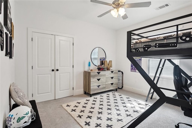 carpeted bedroom with visible vents, a closet, a ceiling fan, and multiple windows