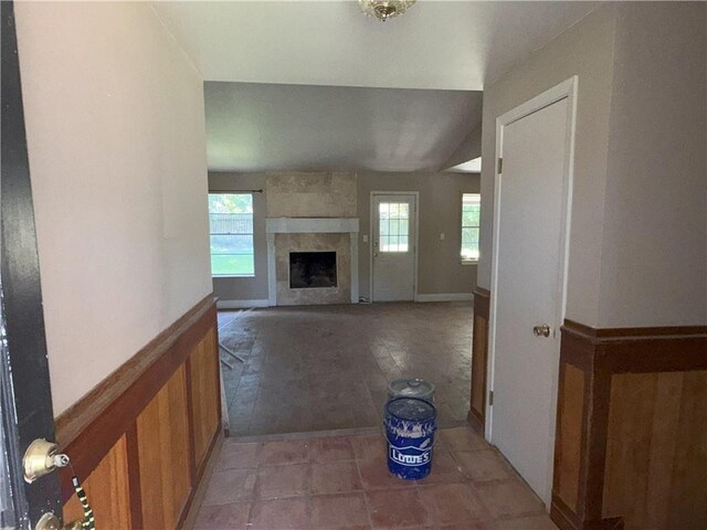 interior space featuring light tile patterned floors, a large fireplace, and plenty of natural light