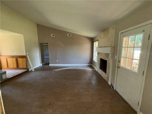 unfurnished living room featuring baseboards, visible vents, a high end fireplace, and lofted ceiling