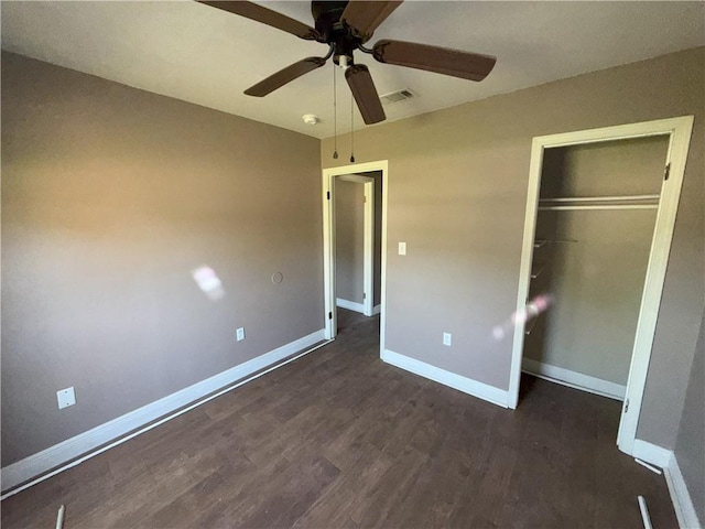 unfurnished bedroom with visible vents, ceiling fan, a closet, baseboards, and dark wood finished floors