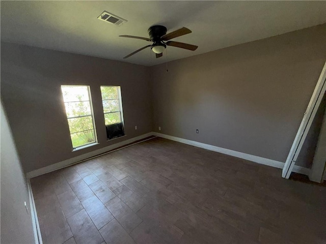 unfurnished room featuring baseboards, visible vents, wood finished floors, and ceiling fan