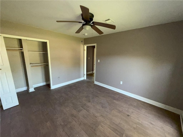 unfurnished bedroom featuring visible vents, ceiling fan, baseboards, a closet, and dark wood-style flooring