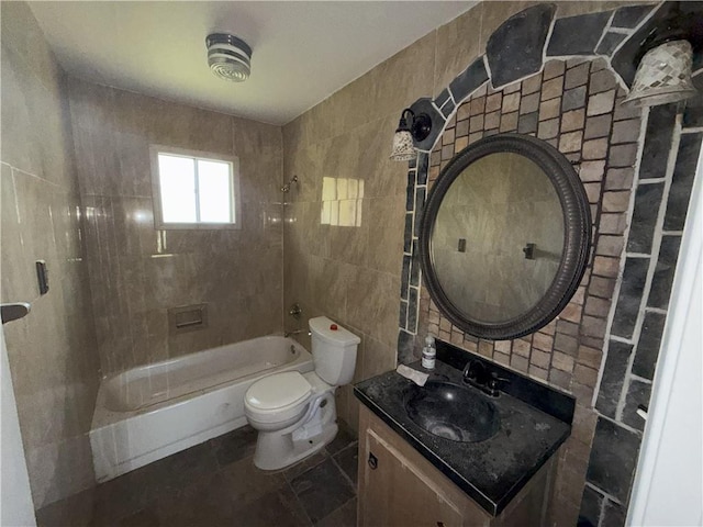 full bath featuring toilet, tile walls, vanity,  shower combination, and tile patterned flooring