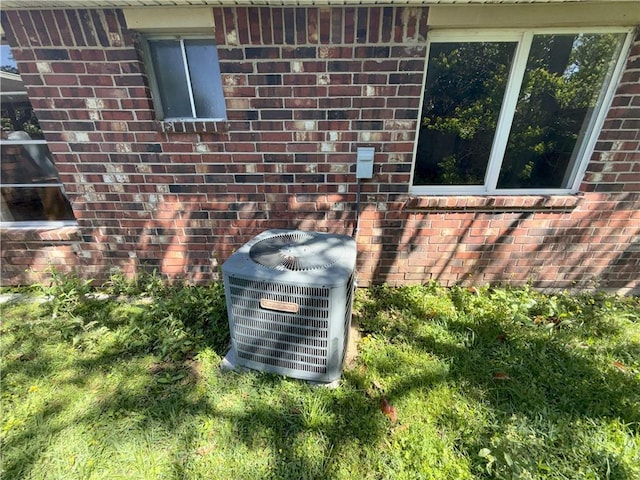 details featuring central AC and brick siding