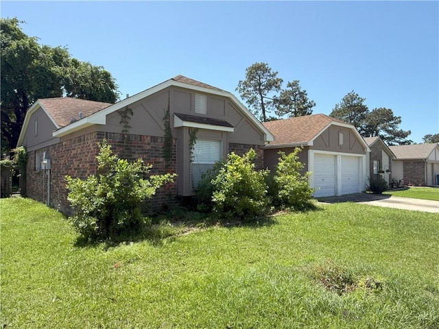 ranch-style house featuring a shingled roof, a front lawn, driveway, and an attached garage