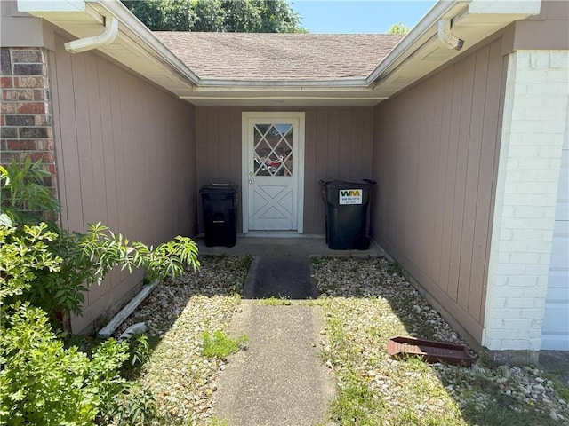entrance to property featuring a shingled roof