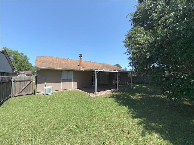 back of house featuring a fenced backyard, a gate, a patio area, central AC, and a lawn