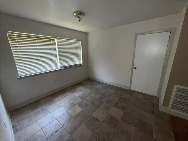 spare room with visible vents and baseboards