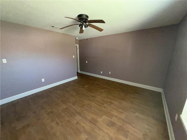 empty room with baseboards, visible vents, wood finished floors, and a ceiling fan