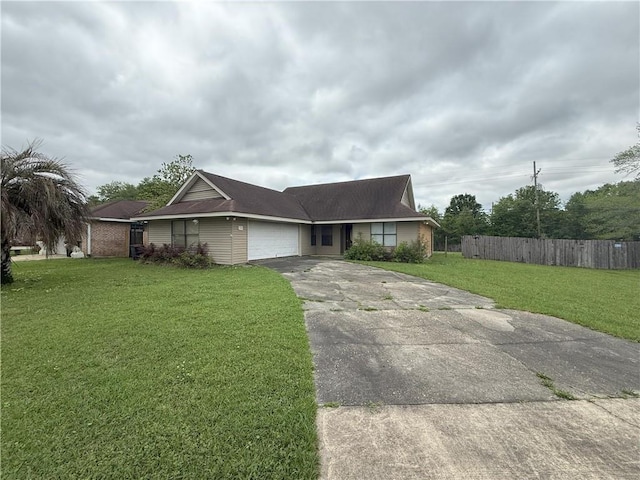 ranch-style house with fence, concrete driveway, a front yard, and an attached garage