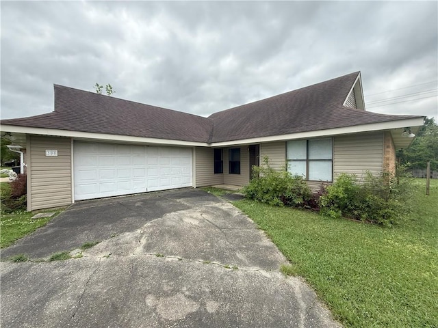 view of front of home with a front yard, aphalt driveway, and an attached garage