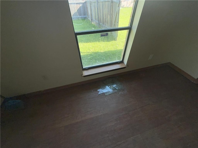 unfurnished room with baseboards and wood finished floors