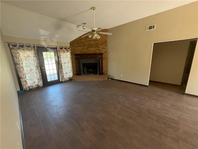 unfurnished living room featuring wood finished floors, vaulted ceiling, ceiling fan, a brick fireplace, and visible vents