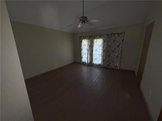 empty room with baseboards, wood finished floors, a ceiling fan, and lofted ceiling