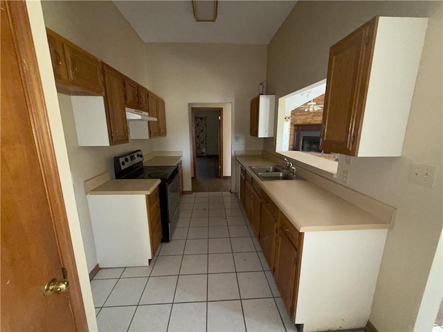 kitchen with a sink, under cabinet range hood, light tile patterned flooring, light countertops, and range with electric stovetop