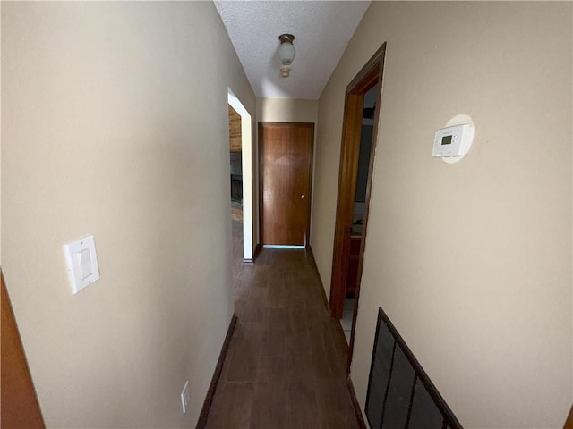hallway featuring wood finished floors and baseboards