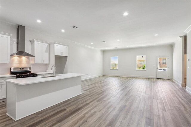 1504 Mason Smith Ave, Metairie, LA 70003 - kitchen featuring a center island with sink, stainless steel gas range, light countertops, wall chimney exhaust hood, and a sink