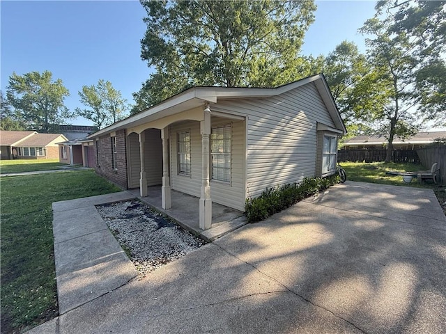 exterior space with a yard, covered porch, and fence