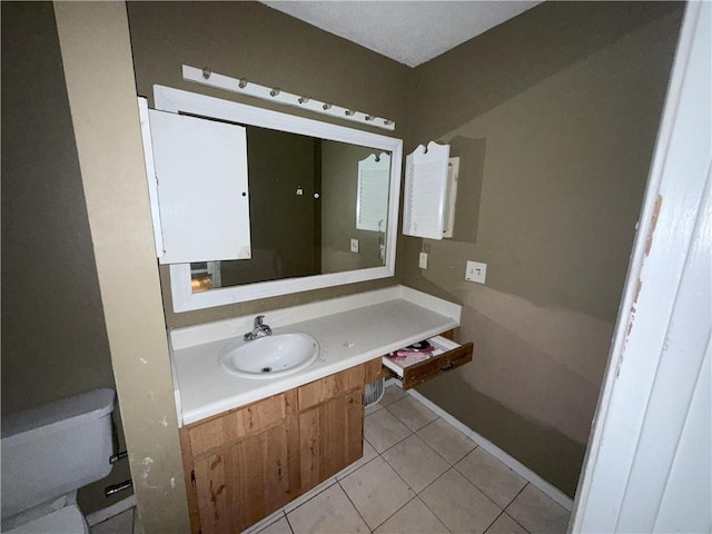 bathroom with vanity, toilet, and tile patterned flooring