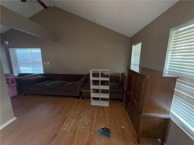 living area with light wood-type flooring, ceiling fan, and vaulted ceiling