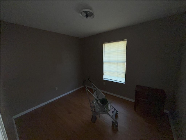 unfurnished room with wood finished floors and baseboards