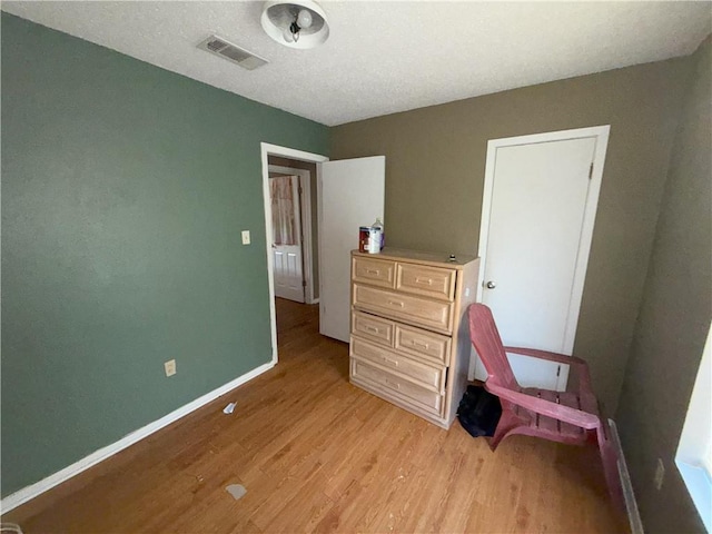 office space featuring light wood finished floors, visible vents, and baseboards