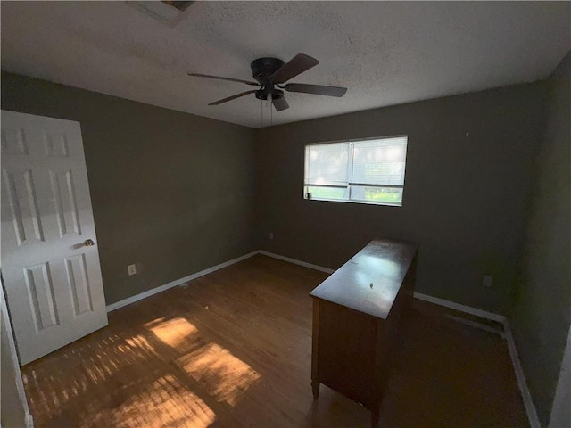 unfurnished bedroom with baseboards, wood finished floors, a ceiling fan, and a textured ceiling