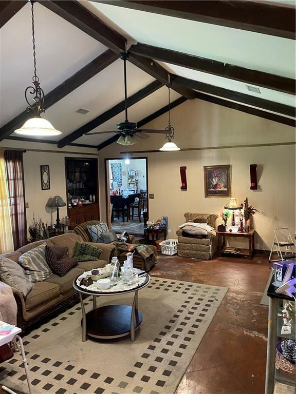 living room with lofted ceiling with beams, a ceiling fan, and visible vents