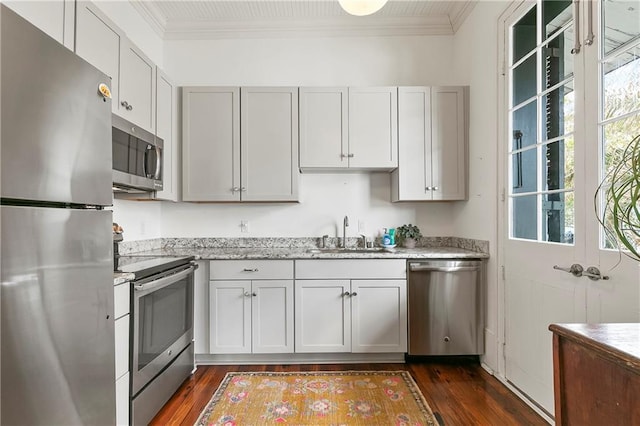 716 Governor Nicholls St Unit C, New Orleans, LA 70116 - kitchen featuring appliances with stainless steel finishes, a sink, ornamental molding, dark wood-type flooring, and light stone counters