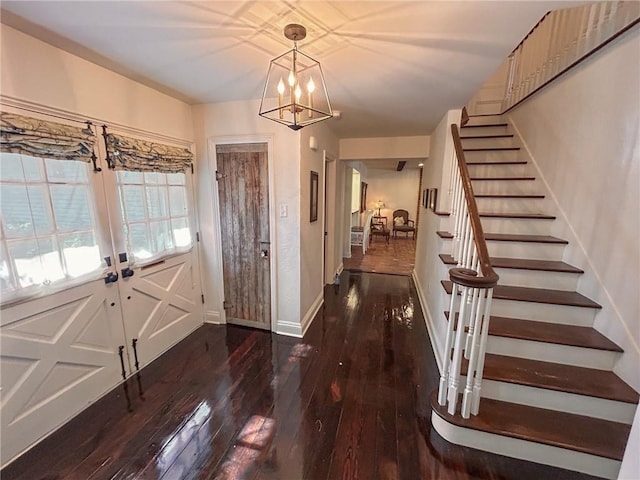 entrance foyer with stairway, a chandelier, baseboards, hardwood / wood-style floors, and french doors